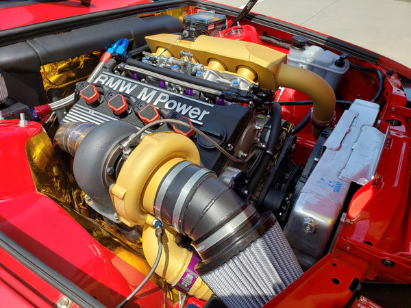 BMW E30 M3 engine bay with custom turbocharger system and fully built dry sump S14 engine by BimmerHeads.