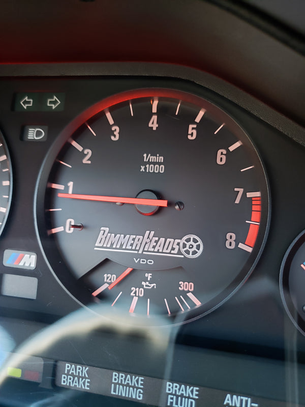 BimmerHeads logo shown on BMW E30 M3 gauge cluster.