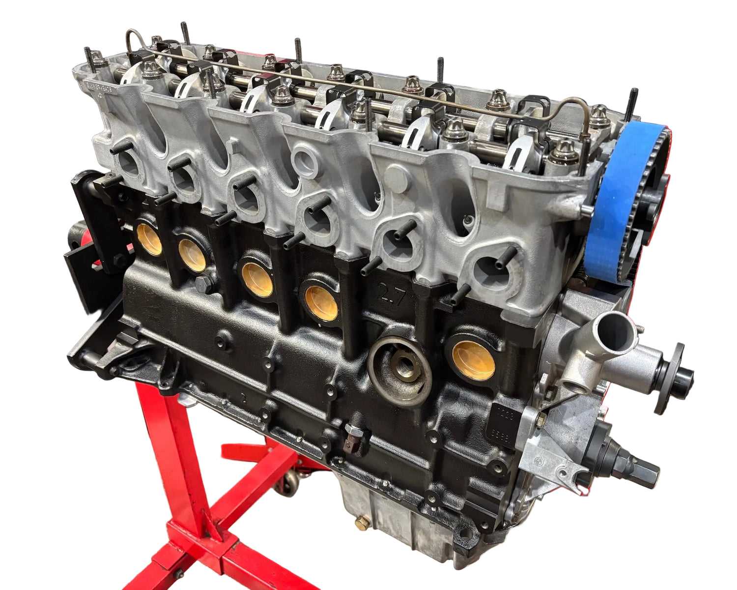 A black BimmerHeads Super Sport BMW M20 2.5L long block engine with cylinder head, valves, and various engine components visible.