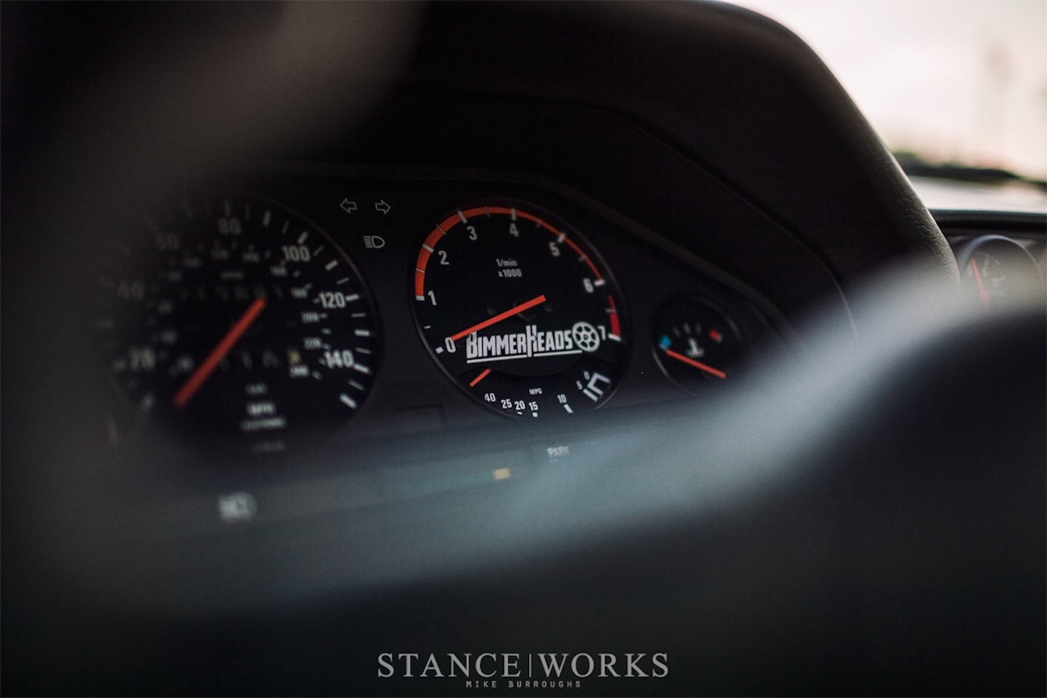 BMW E30 gauge cluster featuring BimmerHeads logo in a photo taken by StanceWorks.