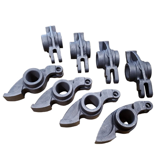 A set of eight gray forged steel rocker arms for a BMW M10 engine.