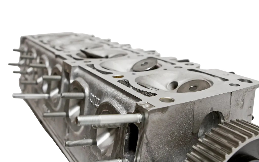 A BimmerHeads Race BMW M20 885 cylinder head with visible valves, studs, and valve springs, showing the back side with the brand logo.