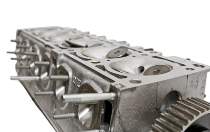 A BimmerHeads Race BMW M20 885 cylinder head with visible valves, studs, and valve springs, showing the back side with the brand logo.