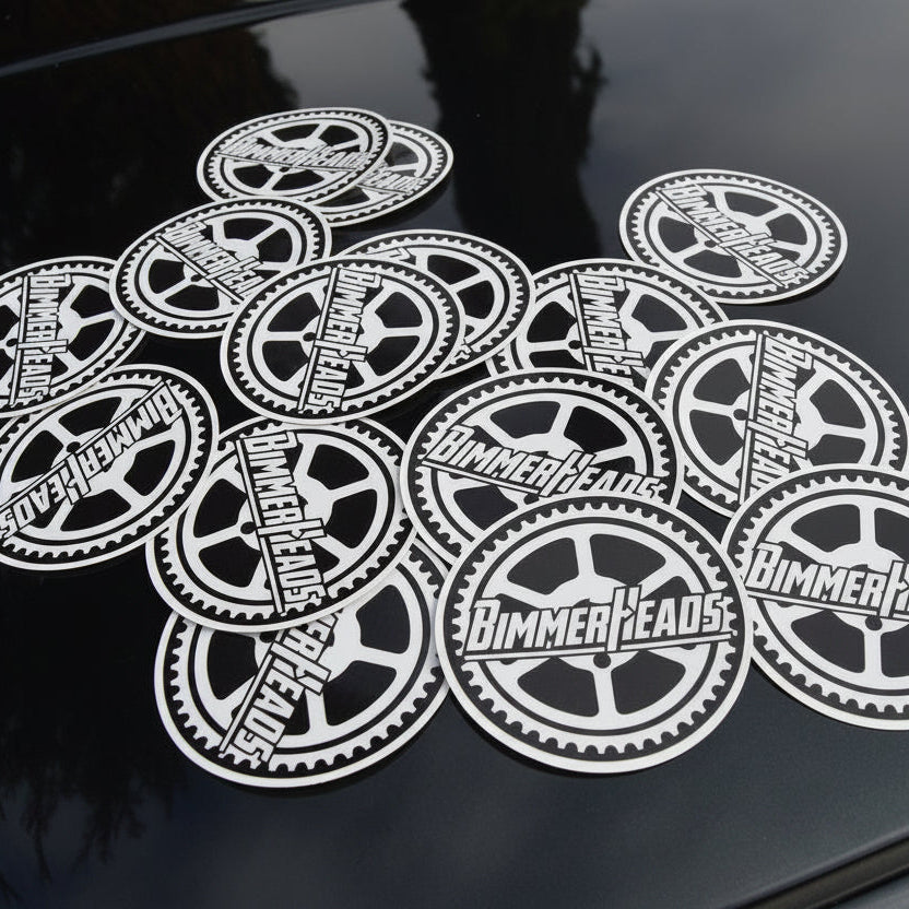Round BimmerHeads stickers displayed on top of BMW E30 hood.